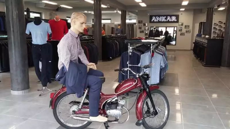 Manekin na motocyklu w sklepie z garniturami